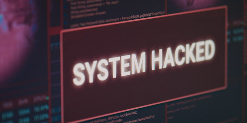 Computer monitor showing hacked system alert message flashing on screen