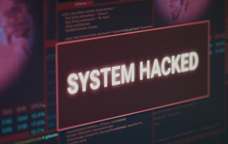 Computer monitor showing hacked system alert message flashing on screen