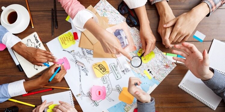 Picture of businessmen’s hands on wooden table with documents and drafts Equipos