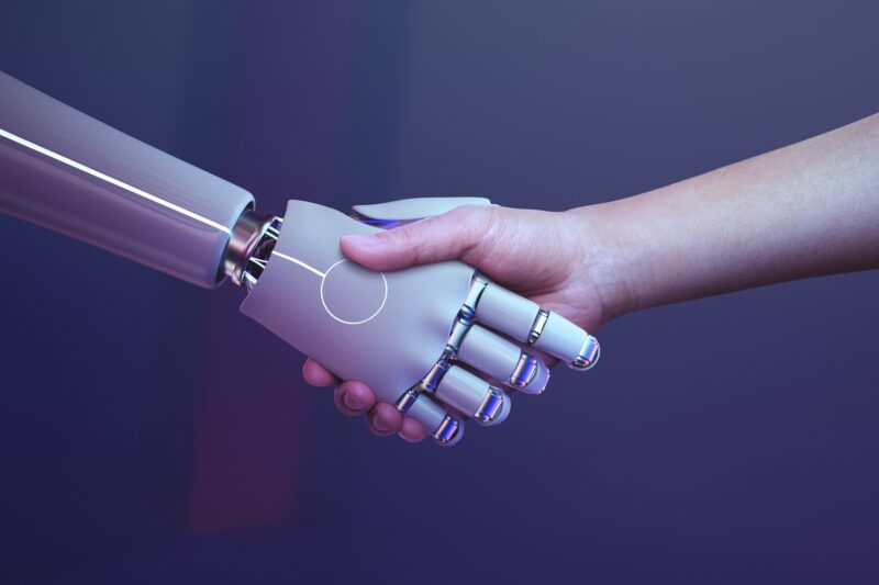 Robot handshake human background, futuristic digital age IA Mayo 2025