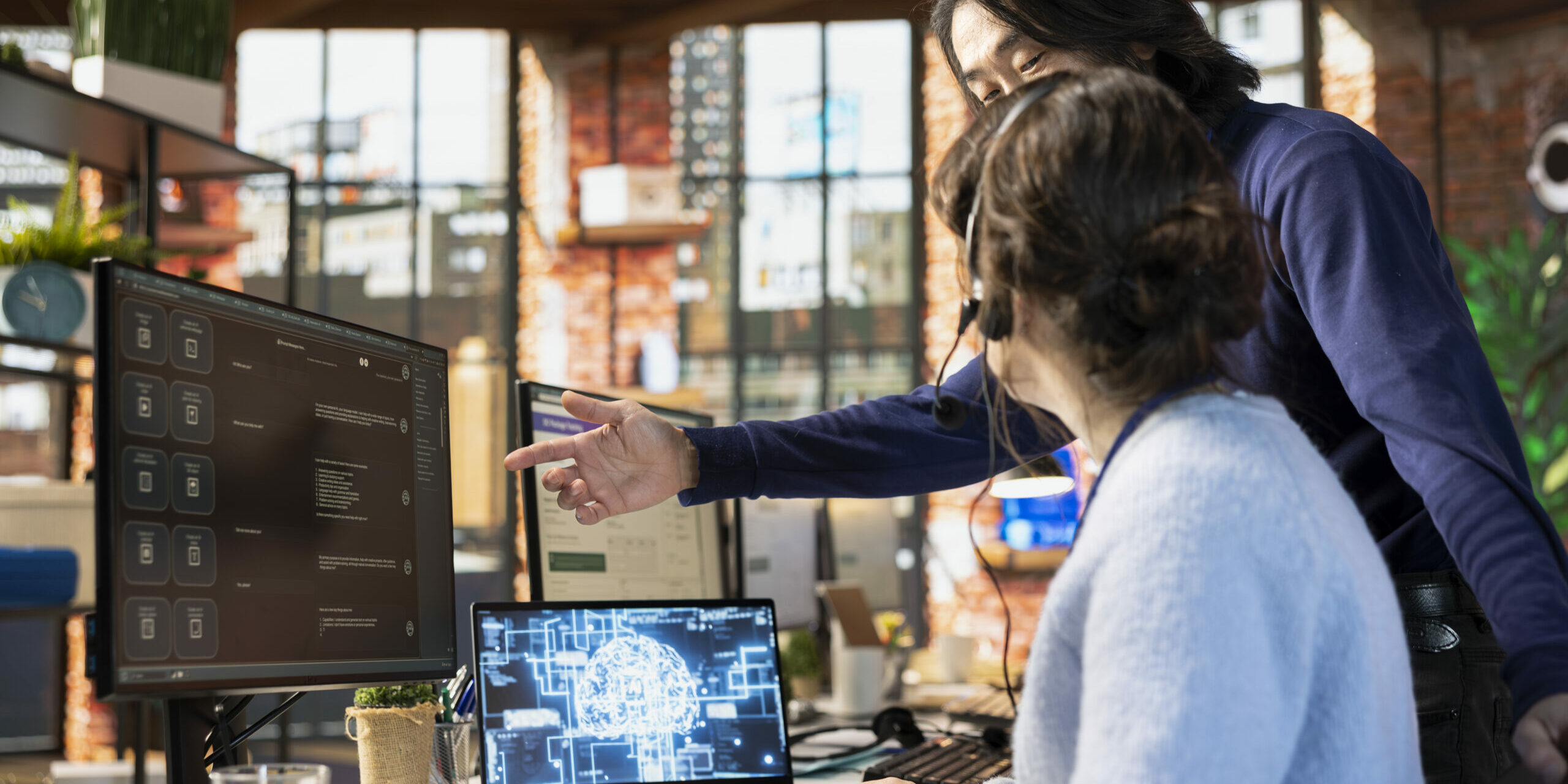 Call center manager guiding intern on how to use AI chatbot at office desk on PC Automatización inteligente